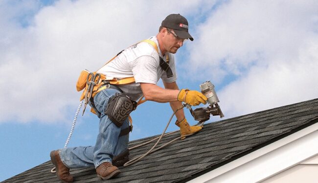 Roofer in safety gear working on roof