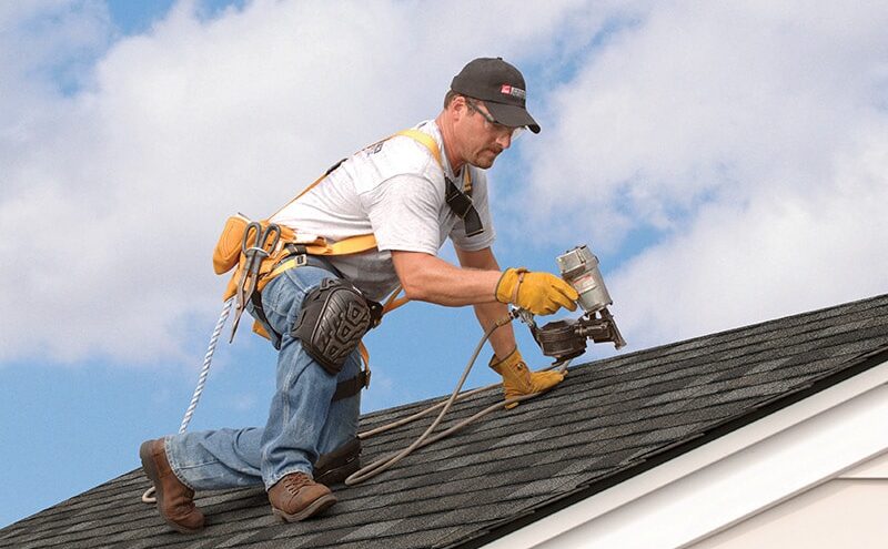 Roofer in safety gear working on roof