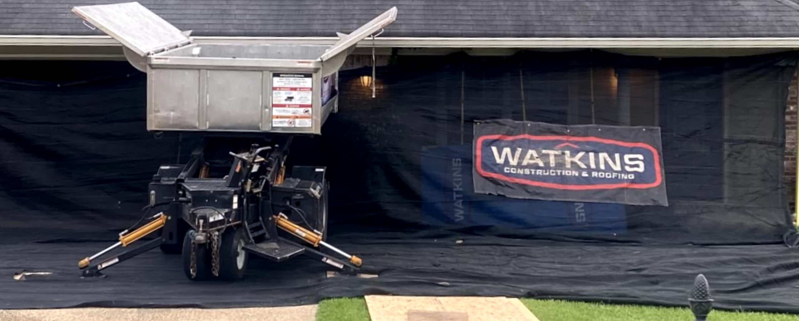 Watkins Catch-All stationed outside a residence. It sits on branded tarps.