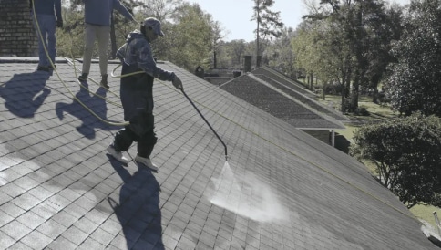 Worker cleaning a roof